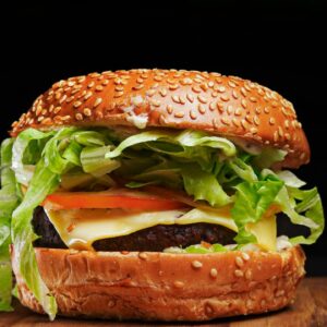 Cheese burger with melted cheese and veg patty Cheesy veg burger with lettuce and sauce Cafe style cheese burger India Street style veg cheese burger