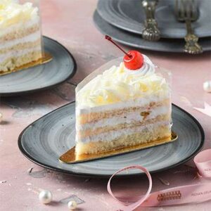 White Forest Pastry creamy cake slice with white chocolate and cherry topping